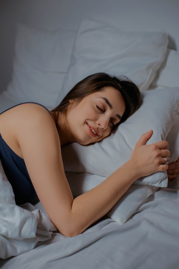 Woman peacefully sleeping in a cozy bedroom setting, exuding relaxation and comfort.
